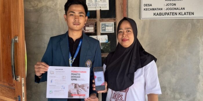 Dorong Digitalisasi UMKM, Mahasiswa KKN UNDIP Permudah Pembayaran dengan QRIS di Desa Joton A person and person standing in front of a building AI-generated content may be incorrect.