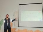 A person standing in front of a projection screen Description automatically generated