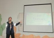 A person standing in front of a projection screen Description automatically generated