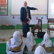 A person teaching a group of children AI-generated content may be incorrect.