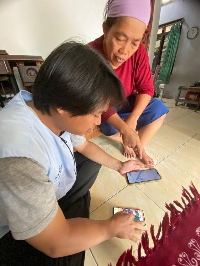 A person and child looking at a cell phone AI-generated content may be incorrect.