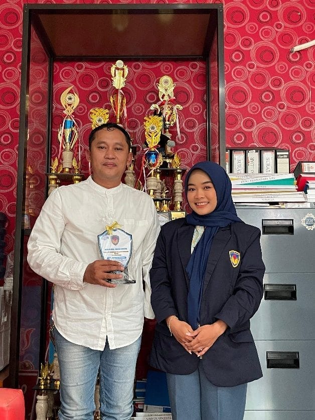 A person and person standing in front of a red wall AI-generated content may be incorrect.