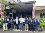 A group of people standing in front of a building Description automatically generated